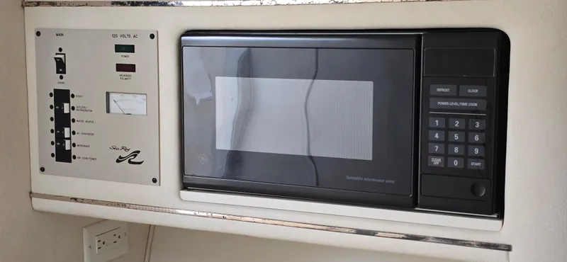 Slide: The Image of 1999 Sea Ray 280 SS interior with microwave and control panel. - 15