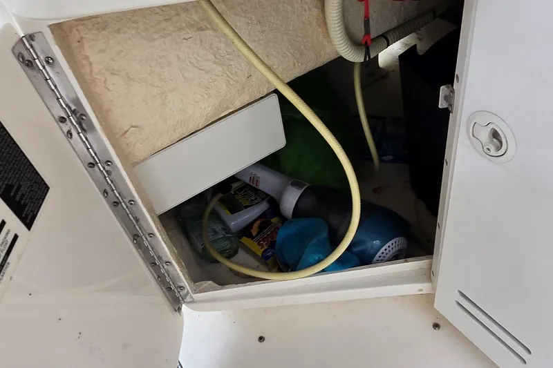 Slide: The Image of Storage compartment in a 1999 Sea Ray 280 SS boat with various items inside. - 18