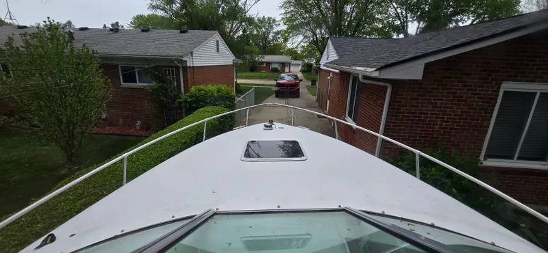 Slide: The Image of Bow view of a 1999 Sea Ray 280 SS boat between brick houses. - 7