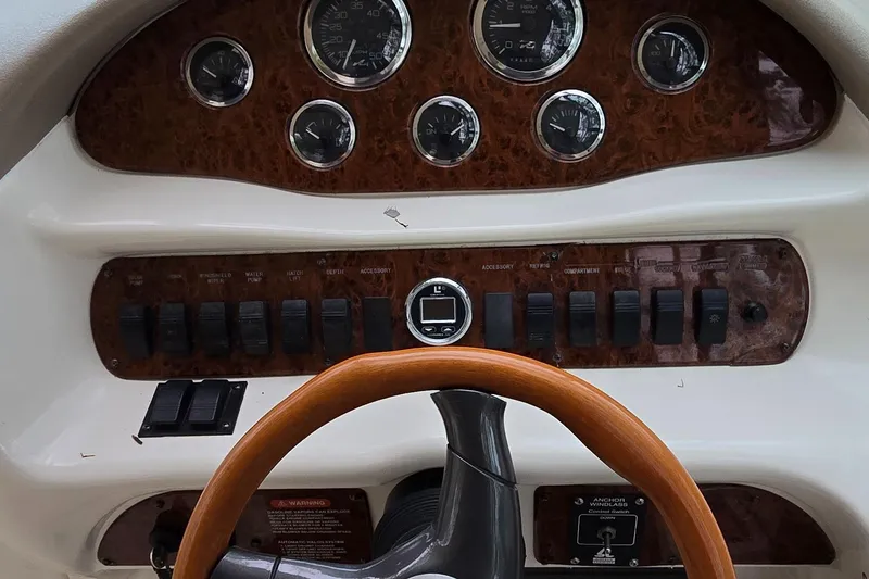 Slide: The Image of 1999 Sea Ray 280 SS dashboard with wood accents and steering wheel. - 8