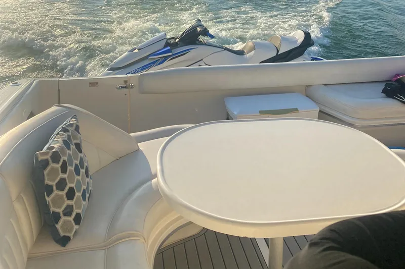 Slide: The Image of Luxury seating area on 1998 Sea Ray 500 Sundancer yacht with watercraft in background. - 3
