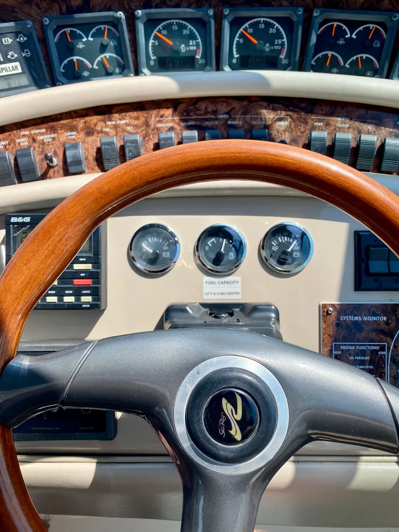 Slide: The Image of 1998 Sea Ray 500 Sundancer dashboard with wood-trimmed steering wheel and gauges. - 5
