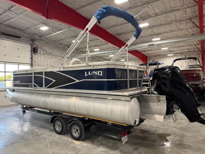 Slide: The Image of 2018 Lund LX 240 pontoon boat in a spacious indoor storage facility. - 3