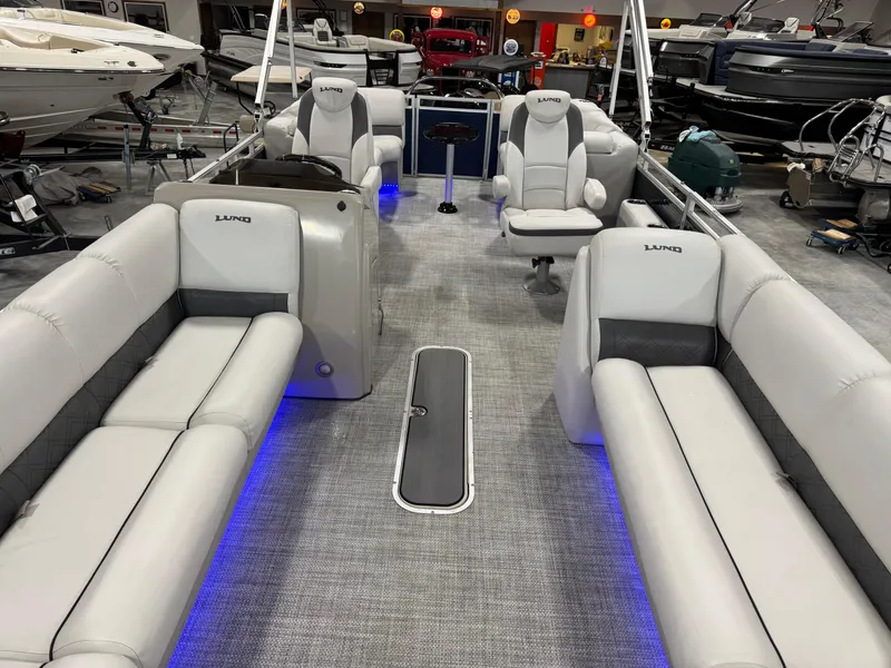 Slide: The Image of 2018 Lund LX 240 pontoon boat with spacious seating and modern interior design. - 8
