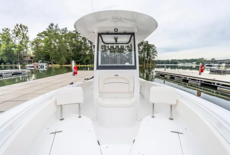 Slide: The Image of 2025 Sea Hunt Ultra 245 SE boat docked by a serene lake. - 7