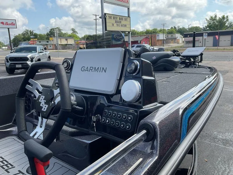 Slide: The Image of 2025 Bass Cat Eyra boat dashboard with Garmin navigation system, parked outdoors. - 12