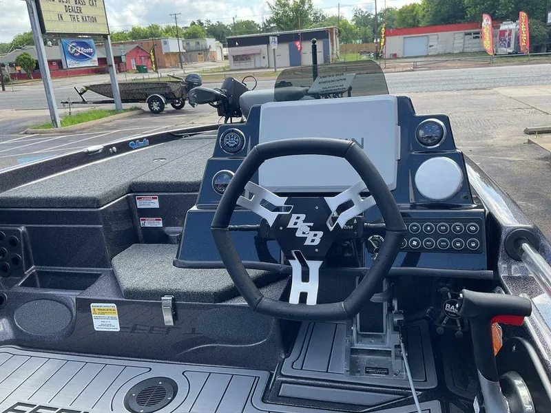 Slide: The Image of 2025 Bass Cat Eyra boat dashboard with steering wheel and electronic controls. - 13