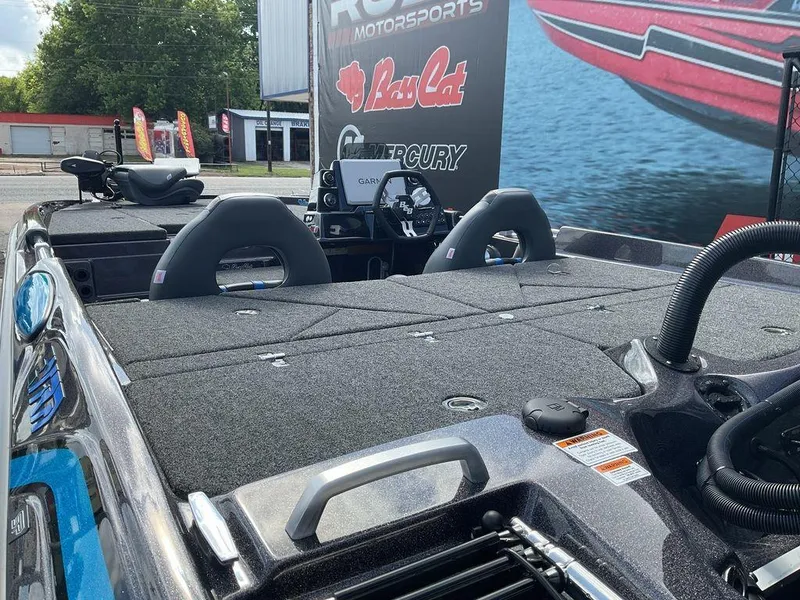 Slide: The Image of 2025 Bass Cat Eyra boat interior with dual seats and control panel, displayed outdoors. - 15