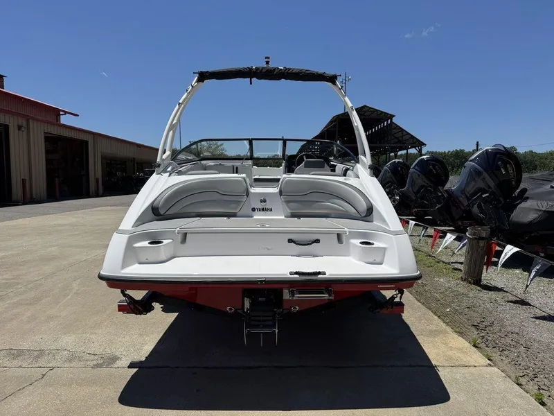 Slide: The Image of 2024 Yamaha AR190 boat, rear view, parked outdoors under clear blue sky. - 2