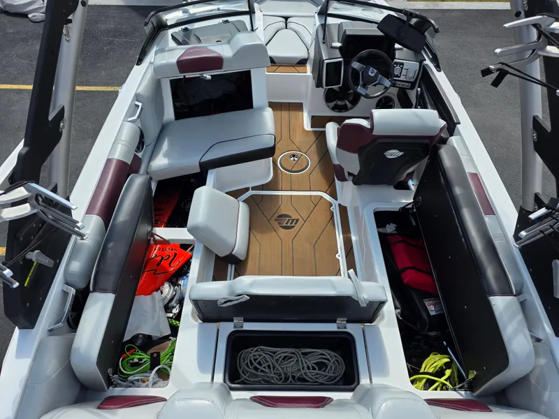 Slide: The Image of 2020 Malibu 21VLX boat interior with seating, storage compartments, and steering console. - 15