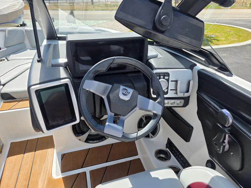 Slide: The Image of Interior dashboard of a 2020 Malibu 21VLX boat with modern controls and steering wheel. - 16