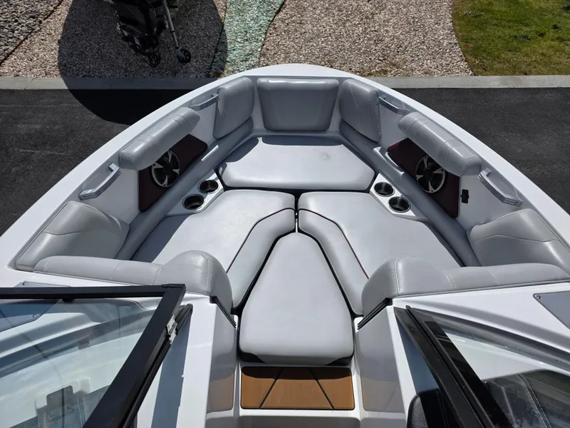 Slide: The Image of 2020 Malibu 21VLX boat interior with plush seating and cup holders. - 17