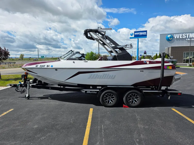 Slide: The Image of 2020 Malibu 21VLX boat on trailer in parking lot, cloudy sky background. - 6