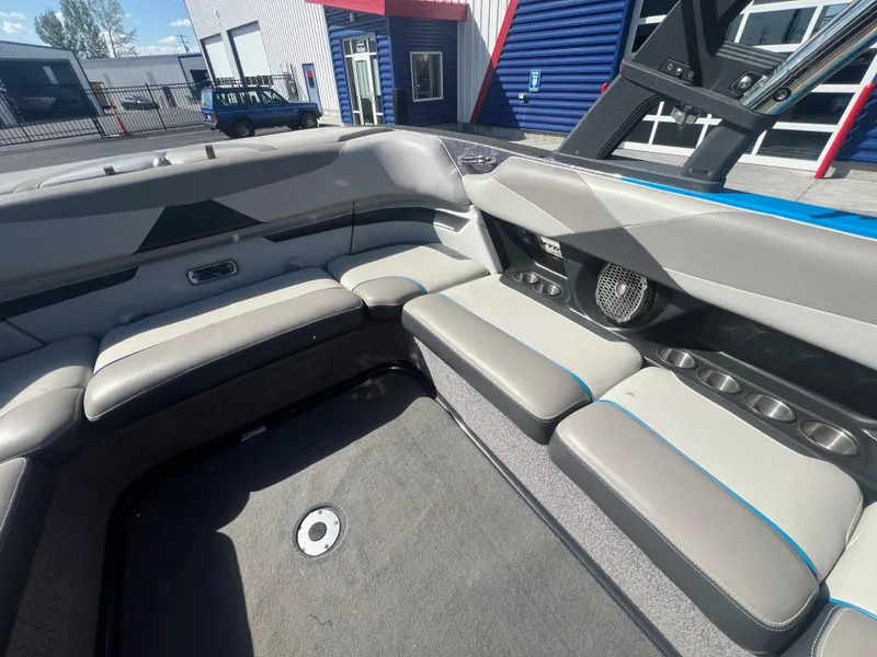 Slide: The Image of Interior of 2014 Malibu W23LSV boat with gray seating and cup holders. - 13