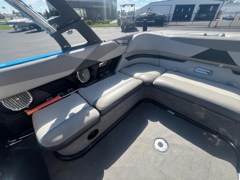 Slide: The Image of 2014 Malibu W23LSV boat interior with gray seating and speaker system. - 14