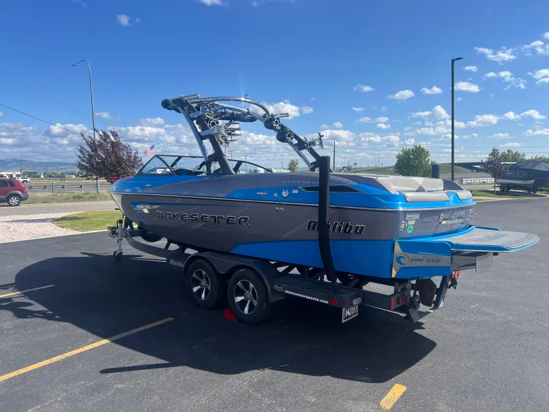 Slide: The Image of 2014 Malibu Wakesetter W23LSV boat on trailer in sunny parking lot. - 6