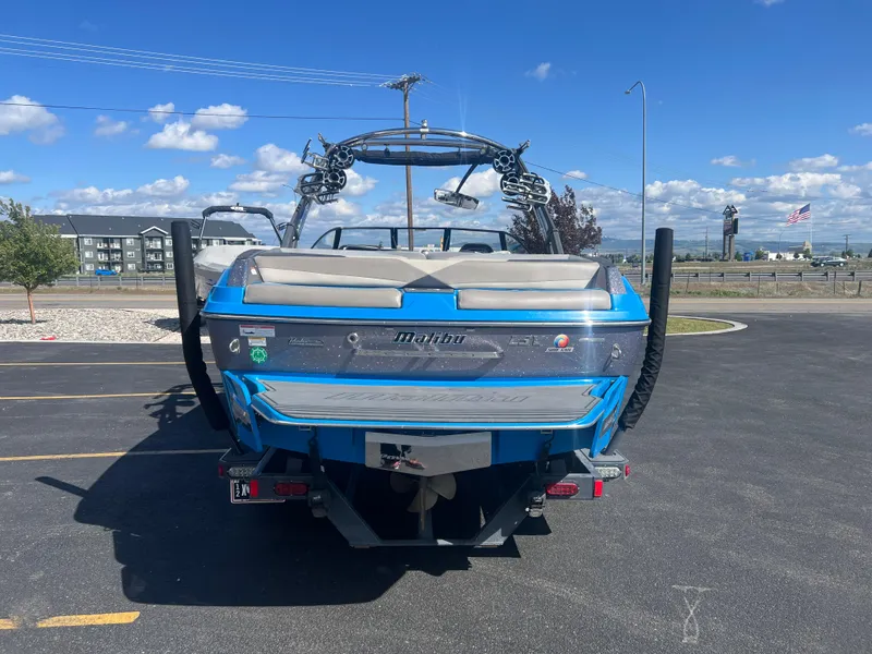 Slide: The Image of 2014 Malibu W23LSV boat in parking lot under clear blue sky. - 7