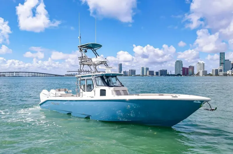 Slide: The Image of 2025 Solace 37 PILOT boat cruising in sunny coastal waters with city skyline. - 9