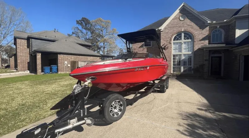 Slide: The Image of Red 2002 Crownline 225LPX boat on trailer in residential driveway, sunny day. - 2