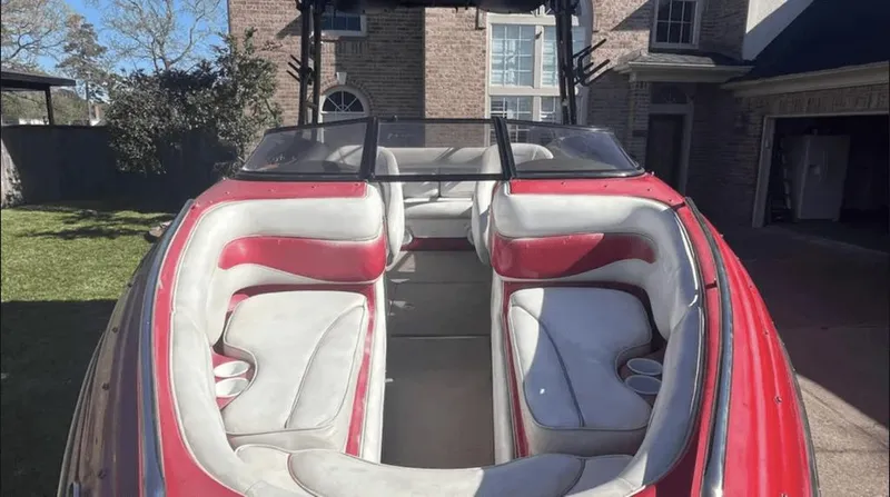 Slide: The Image of 2002 Crownline 225LPX boat with red and white interior, parked in a residential driveway. - 4
