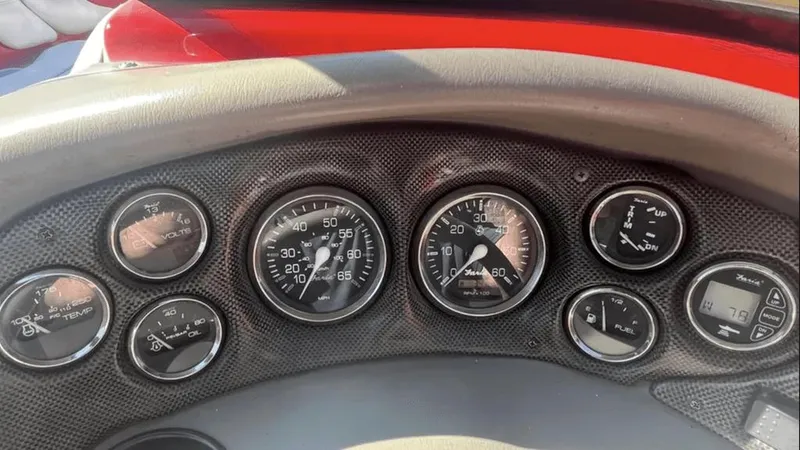 Slide: The Image of Dashboard of a 2002 Crownline 225LPX boat with various gauges and controls. - 5