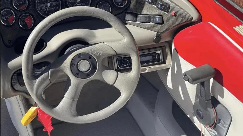 Slide: The Image of 2002 Crownline 225LPX boat dashboard with steering wheel and control panel. - 7