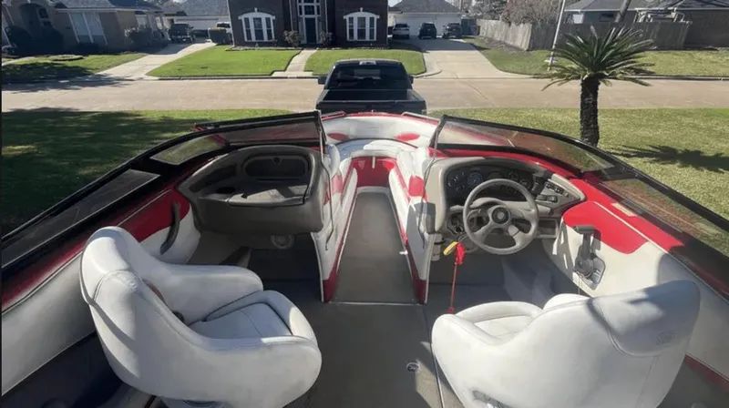 Slide: The Image of Interior of 2002 Crownline 225LPX boat with white and red seating, parked in driveway. - 8