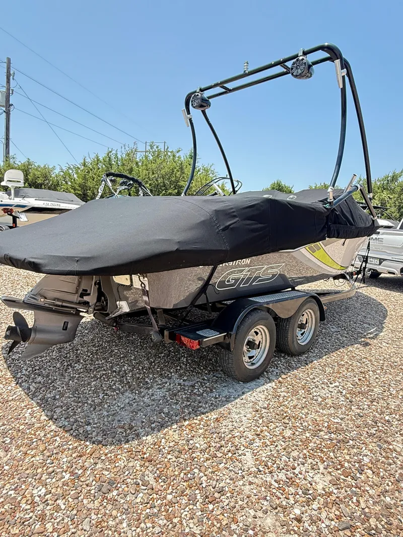 Slide: The Image of 2017 Glastron GTS 205 boat on trailer, covered, parked on gravel. - 2
