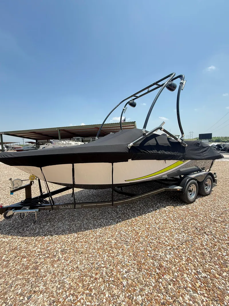Slide: The Image of 2017 Glastron GTS 205 boat on trailer, covered, parked on gravel lot. - 4