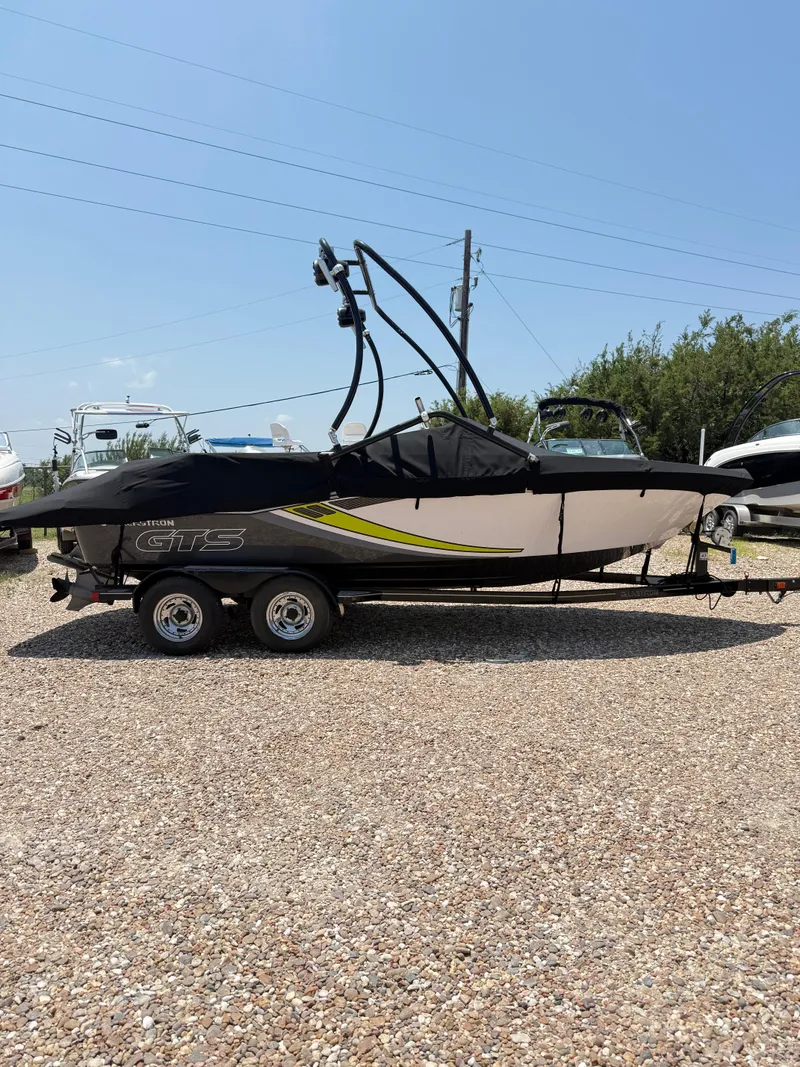 Slide: The Image of 2017 Glastron GTS 205 boat on trailer, covered, parked on gravel lot. - 5
