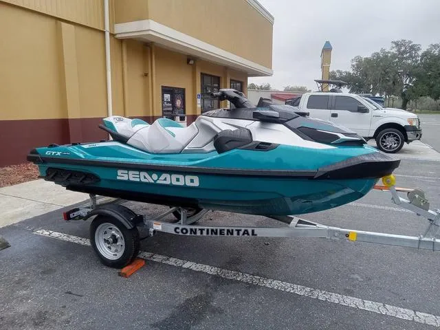 Slide: The Image of 2025 Sea-Doo GTX Waverunner on trailer, parked outside a building. - 16