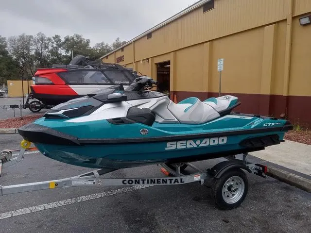 Slide: The Image of 2025 Sea-Doo GTX Waverunner on trailer, parked outside a building. - 9
