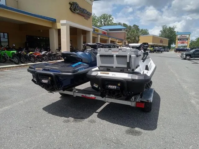 Slide: The Image of 2025 Sea-Doo Waverunner FISH PROs on trailer outside dealership under cloudy sky. - 10