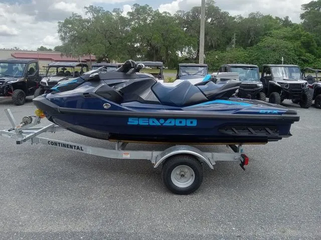 Slide: The Image of 2025 Sea-Doo Waverunner FISH PRO on trailer, parked outdoors with trees in background. - 13