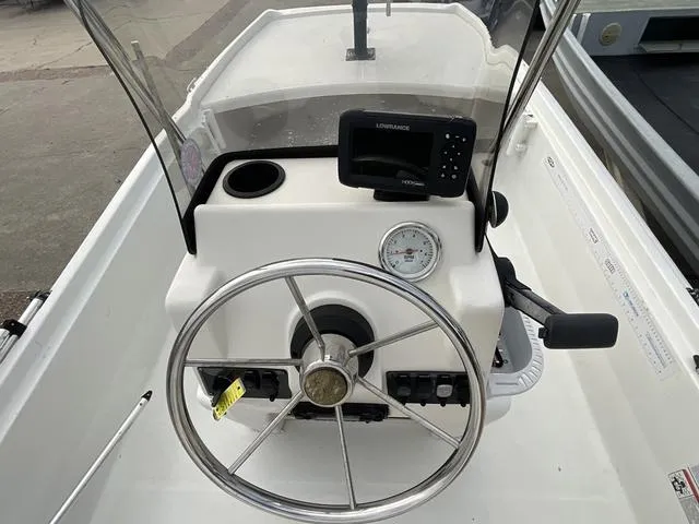 Slide: The Image of 2012 Mako Pro Skiff boat console with steering wheel and navigation equipment. - 12