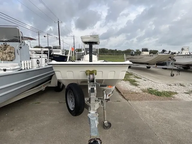 Slide: The Image of 2012 Mako Pro Skiff boat on trailer, parked outdoors under cloudy sky. - 2