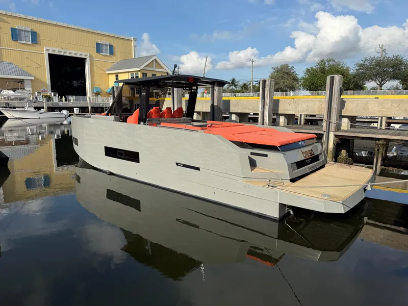 Slide: The Image of 2021 De Antonio Yachts D42 docked, featuring sleek design and vibrant orange seating. - 1