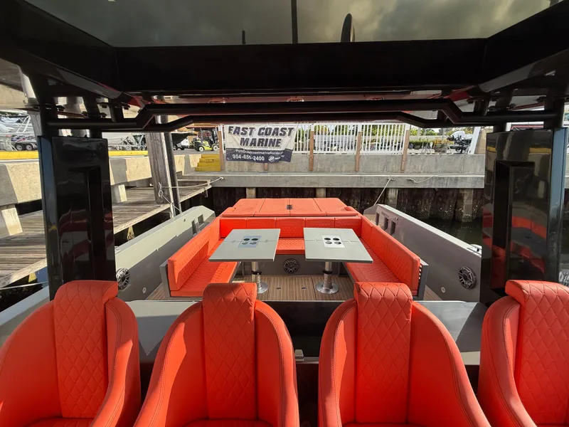 Slide: The Image of 2021 De Antonio Yachts D42 with vibrant red seating and dual tables at a marina. - 11