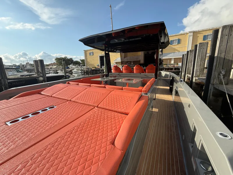 Slide: The Image of De Antonio Yachts D42, 2021 model, featuring vibrant orange seating at a marina. - 23