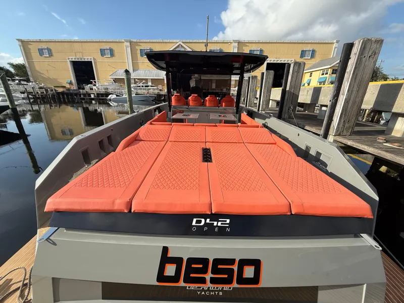 Slide: The Image of 2021 De Antonio Yachts D42 with orange seating, docked at a marina. - 24