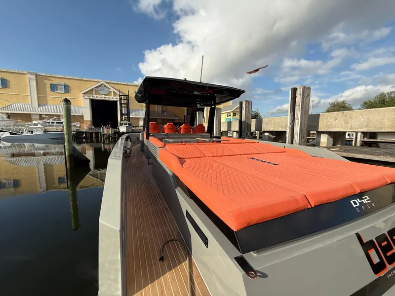 Slide: The Image of De Antonio Yachts D42 2021 model docked, featuring vibrant orange seating and sleek design. - 25