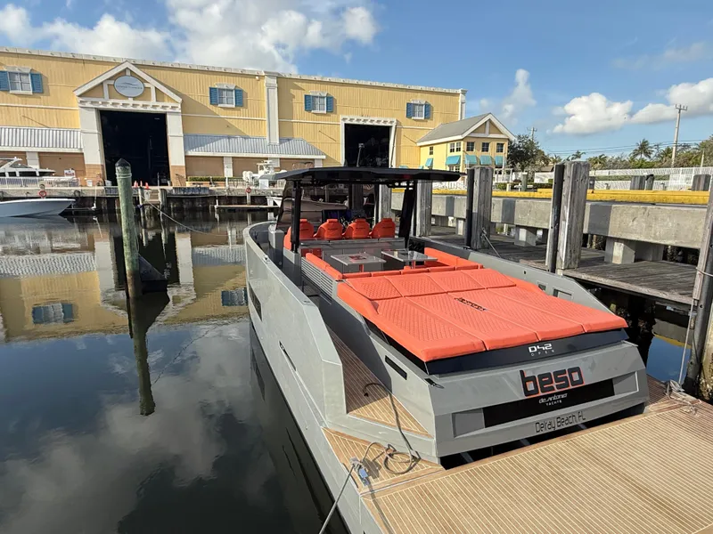 Slide: The Image of 2021 De Antonio Yachts D42 docked, featuring sleek design and vibrant orange seating. - 29