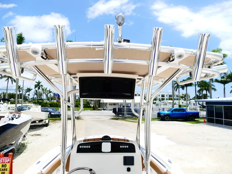 Slide: The Image of 2026 Pioneer 202 Islander boat with T-top and electronics, parked outdoors under blue sky. - 16