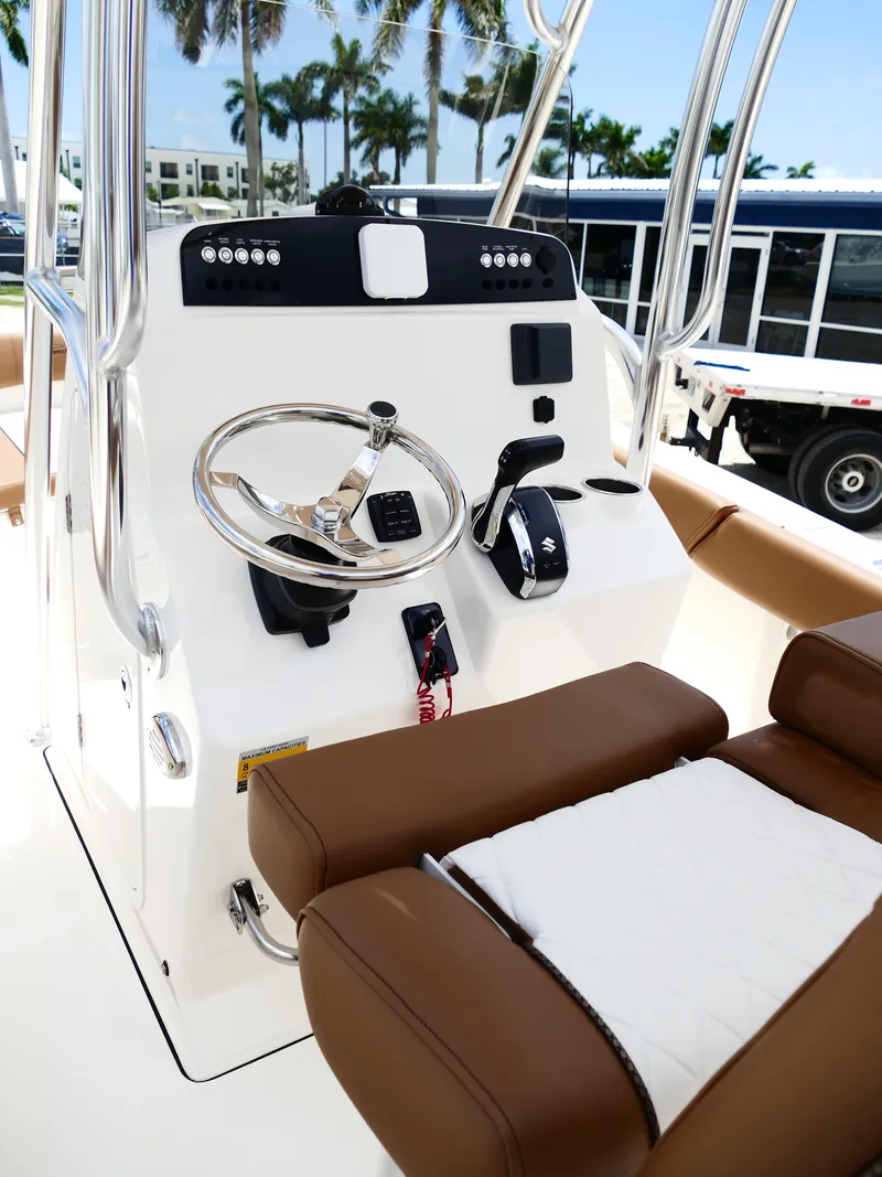 Slide: The Image of 2026 Pioneer 202 Islander boat console with steering wheel and controls, featuring brown seating. - 21