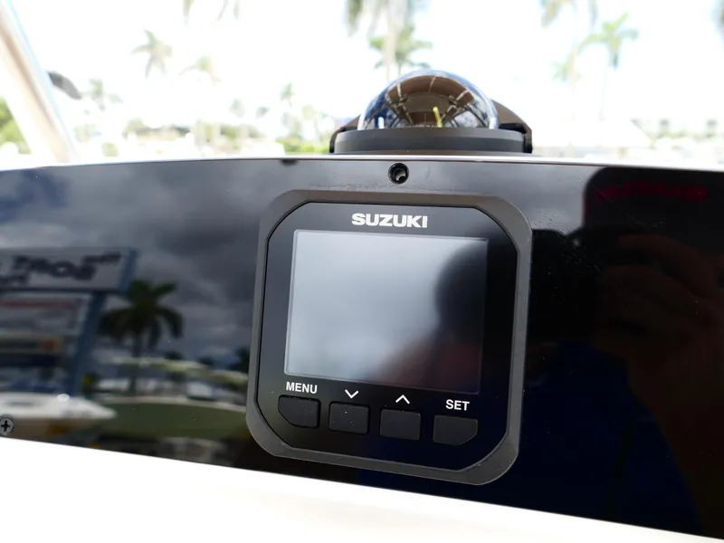 Slide: The Image of Suzuki display on 2026 Pioneer 202 Islander boat dashboard with palm trees in background. - 23
