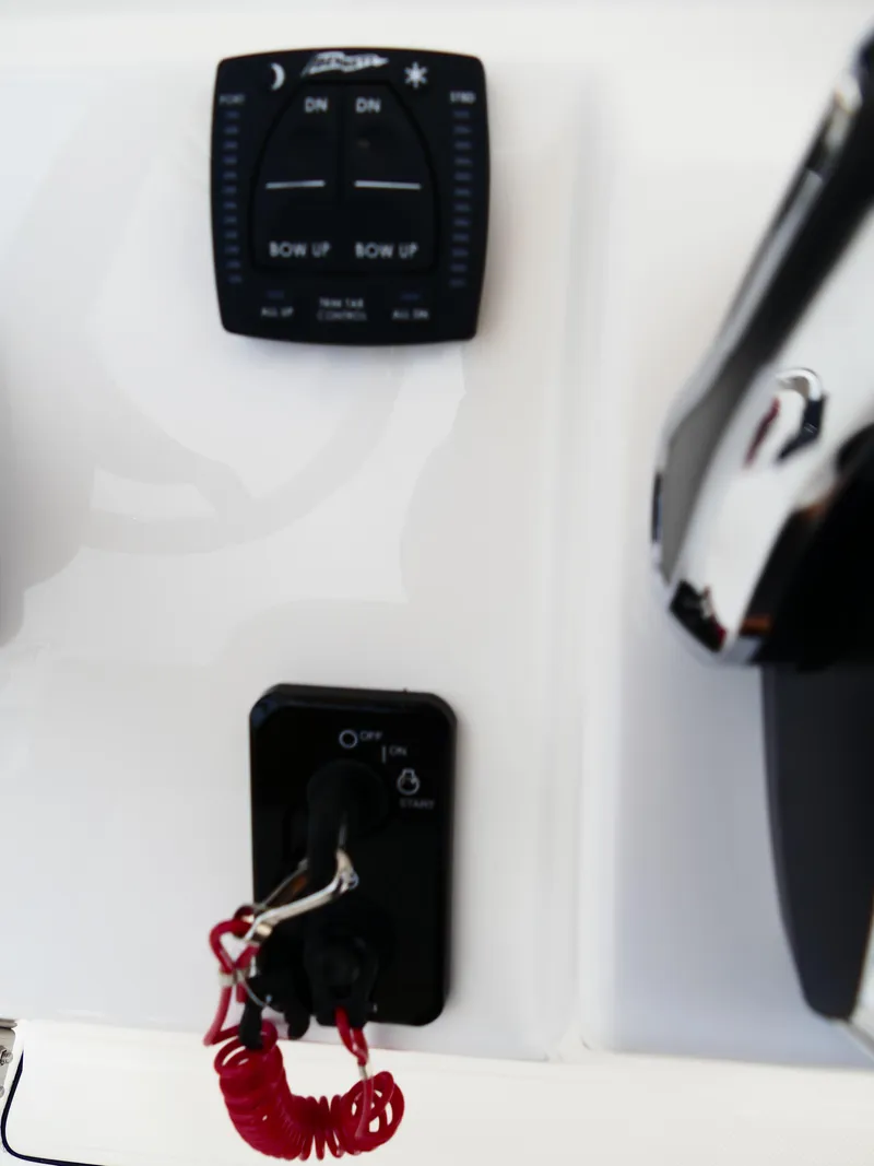 Slide: The Image of Control panel of 2026 Pioneer 202 Islander boat with ignition and trim tab switches. - 28