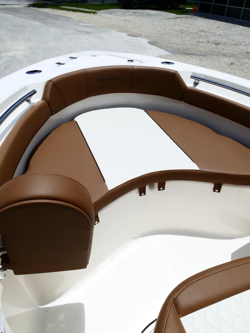 Slide: The Image of 2026 Pioneer 202 Islander boat interior with brown and white cushioned seating. - 32