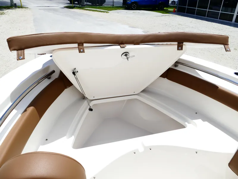 Slide: The Image of 2026 Pioneer 202 Islander boat interior with open storage compartment and brown seating. - 34