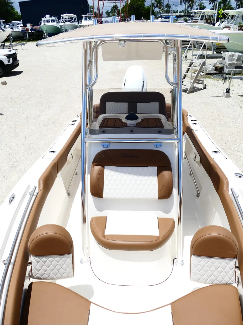 Slide: The Image of 2026 Pioneer 202 Islander boat with tan and white seating, docked outdoors. - 39
