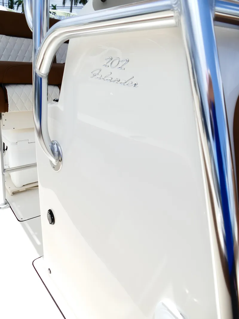 Slide: The Image of 2026 Pioneer 202 Islander boat interior with chrome railing and white seating. - 43